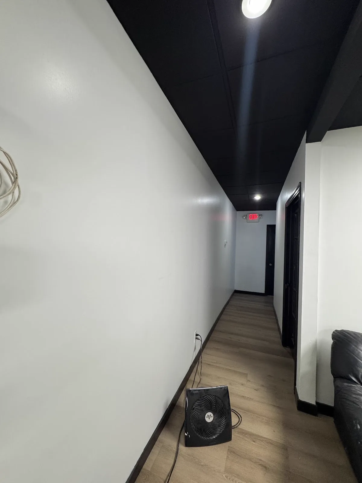 Commercial hallway with fresh white walls and a black-painted exposed ceiling
