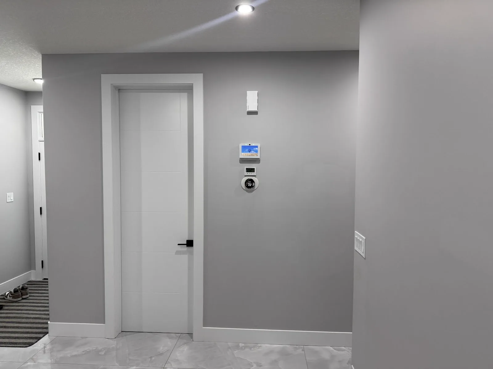 Modern hallway with freshly painted grey walls, white doors and pot lights