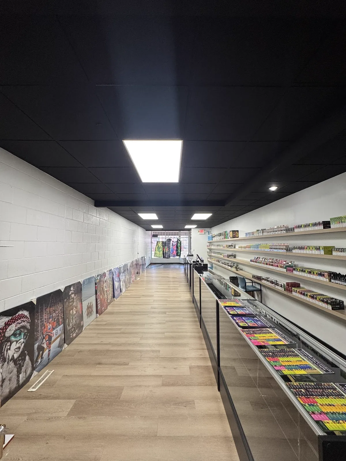 Second angle of the finished retail interior with black ceiling and display cases